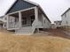 View of home's covered porch with white columns and steps leading to the yard at 1154 E Witherspoon Dr, Elizabeth, CO 80107