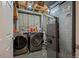Laundry room featuring appliances, storage shelves, and concrete walls at 11296 Daisy Ct, Firestone, CO 80504