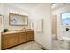 Bathroom with double sinks, wood cabinets, and a shower at 17865 Smugglers Rd, Monument, CO 80132