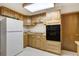 Compact kitchenette area featuring wooden cabinets and black appliances at 17865 Smugglers Rd, Monument, CO 80132