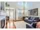 Bright living room with hardwood floors, fireplace, and a soaring two-story ceiling with large windows at 2649 Westgate Ave, Highlands Ranch, CO 80126