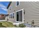 Backyard with small stone patio and green grass leading to sliding glass door at 3429 Hardin St, Castle Rock, CO 80109