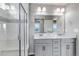 Modern bathroom featuring dual sinks, granite countertops, shower with glass door, and stylish lighting at 3429 Hardin St, Castle Rock, CO 80109