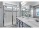 Bathroom showcasing double sinks with large mirrors and a glass-enclosed shower with built in bench at 3429 Hardin St, Castle Rock, CO 80109