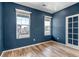 Serene bedroom with fresh blue walls, hardwood floors and natural light at 3429 Hardin St, Castle Rock, CO 80109