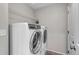 Modern laundry room featuring white washer and dryer with wire shelving above at 3429 Hardin St, Castle Rock, CO 80109