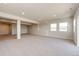 Finished basement with large support beams, neutral carpeting and bright windows at 37094 Still Rock Pt, Elizabeth, CO 80107