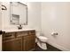 Stylish powder room with a vanity, toilet, and contemporary mirror at 37094 Still Rock Pt, Elizabeth, CO 80107