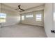 A light filled bedroom featuring tray ceilings, multiple windows, and a ceiling fan at 37094 Still Rock Pt, Elizabeth, CO 80107