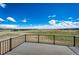 Expansive outdoor deck with black metal railing overlooking rolling landscape and big blue skies at 37094 Still Rock Pt, Elizabeth, CO 80107