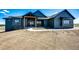 Beautiful home featuring a dark gray exterior with a wood portico and light-colored concrete walkway at 37094 Still Rock Pt, Elizabeth, CO 80107
