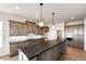 Modern kitchen featuring a large island with stone countertops, pendant lighting, and custom cabinets at 37094 Still Rock Pt, Elizabeth, CO 80107