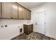 Well-lit laundry room with plenty of cabinet space and a utility sink at 37094 Still Rock Pt, Elizabeth, CO 80107