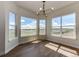 Bright living room showcasing hardwood floors, a stylish chandelier, and large windows with scenic views at 37094 Still Rock Pt, Elizabeth, CO 80107