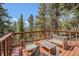 Outdoor deck with wooden furniture, perfect for relaxing amidst the surrounding trees at 11557 Green Cir, Conifer, CO 80433