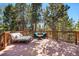 Outdoor deck featuring comfortable seating arrangements amidst a lush forest setting at 11557 Green Cir, Conifer, CO 80433