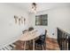 Charming dining area featuring a rustic wood table, modern lighting, and scenic window view at 11557 Green Cir, Conifer, CO 80433