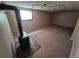 Basement Gathering room area with carpet, a wood burning stove, and a window allowing natural light at 3735 S Lewiston St, Aurora, CO 80013
