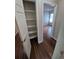 Hallway with wood floors, an open closet with shelving, and a view into a room with natural light at 3735 S Lewiston St, Aurora, CO 80013