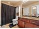 Bathroom featuring granite countertops, cherry cabinets, and shower with black curtain at 12770 Jasmine Ct, Thornton, CO 80602