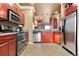 Well-appointed kitchen with stainless steel appliances, wood cabinets, and an open layout to the dining and living area at 12770 Jasmine Ct, Thornton, CO 80602