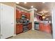 Stylish kitchen with stainless steel appliances, wood cabinets, and tile flooring at 12770 Jasmine Ct, Thornton, CO 80602
