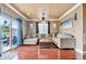 Spacious living room featuring hardwood floors, a comfortable gray sectional, and natural light from sliding glass doors at 12770 Jasmine Ct, Thornton, CO 80602