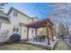Backyard patio with stone pavers, a wooden pergola, and an outdoor dining area at 3183 W 114Th Loop, Westminster, CO 80031