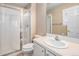 Bright bathroom with a glass-enclosed shower, white vanity with sink, toilet and a window for natural light at 3183 W 114Th Loop, Westminster, CO 80031