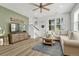 Spacious living room with L-shaped sofa, large TV, and ceiling fan at 9275 Merino Ct # A, Littleton, CO 80125