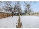 Snowy backyard with pathway to house at 1770 Akron St, Aurora, CO 80010