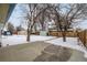 Snowy backyard with storage shed and trees at 1770 Akron St, Aurora, CO 80010