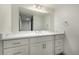 White bathroom vanity with quartz countertop and modern mirror at 1770 Akron St, Aurora, CO 80010