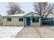 Tan house with blue accents, covered porch, and snow-covered yard at 1770 Akron St, Aurora, CO 80010