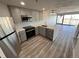 Stylish kitchen with stainless steel appliances, quartz counters, herringbone backsplash, and abundant natural light at 100 Park Ave # 1405, Denver, CO 80205