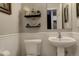 Charming half bathroom with white wainscoting, stylish fixtures, and decorative wall shelves at 841 Crisman Dr # 9, Longmont, CO 80501