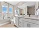 Sunlit bathroom features a double vanity, granite countertops, framed mirror and white cabinetry at 3353 N Catawba Way, Aurora, CO 80019