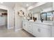 Bright bathroom featuring double vanity sinks, a large mirror, and a walk-in shower at 3353 N Catawba Way, Aurora, CO 80019