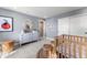 Stylish Bedroom with a modern crib, white dresser, and a cozy round carpet, creating a serene space at 3353 N Catawba Way, Aurora, CO 80019