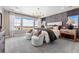 Modern bedroom features a large window, stylish chandelier, accent wall, and two cozy chairs at 3353 N Catawba Way, Aurora, CO 80019