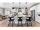 A kitchen featuring a white island with black stools and modern lighting fixtures above it at 3353 N Catawba Way, Aurora, CO 80019