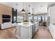 An open kitchen with an island, seamlessly blending into the living and dining areas with expansive windows at 3353 N Catawba Way, Aurora, CO 80019