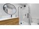 Updated bathroom showcasing a stylish vanity, round mirror, and modern glass-enclosed shower with marble tile at 867 Hill And Dale Rd # B, Golden, CO 80401