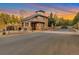 Beautiful entrance gate with stone columns and black iron fencing nestled amongst trees at sunset at 867 Hill And Dale Rd # B, Golden, CO 80401