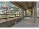 Covered patio with brick flooring and a black metal railing, offering a serene view of the surrounding lush trees at 867 Hill And Dale Rd # B, Golden, CO 80401