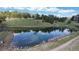 Community pond surrounded by trees and grassy hills at 867 Hill And Dale Rd # B, Golden, CO 80401