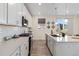 Well-lit kitchen featuring white cabinets, subway tile backsplash, stainless steel appliances, and quartz countertops at 1953 Morgan Dr, Erie, CO 80516