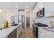 Contemporary kitchen featuring white cabinetry, stainless steel appliances, and a view of the pantry at 1953 Morgan Dr, Erie, CO 80516