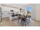 Bright kitchen and dining area featuring white cabinets, island seating, and a sliding glass door to the backyard at 1953 Morgan Dr, Erie, CO 80516
