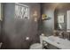 Modern half bathroom with stylish fixtures, dark walls, and a unique sink at 6619 Mariposa Ct, Denver, CO 80221